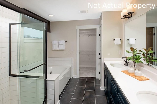 bathroom featuring visible vents, a sink, a spacious closet, tile patterned floors, and a bath