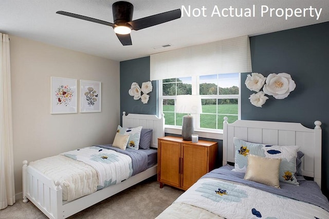 bedroom with visible vents, light colored carpet, and a ceiling fan