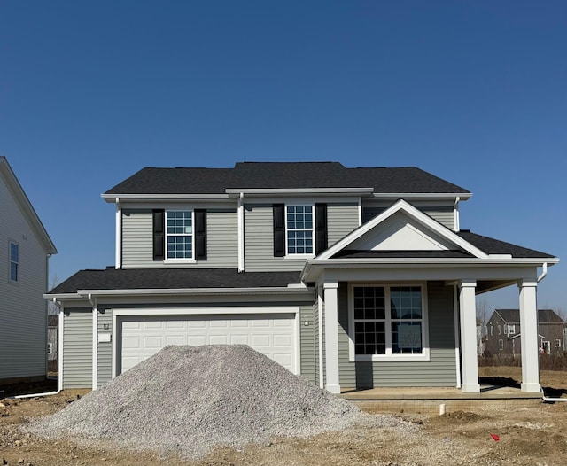 traditional-style home featuring a garage, roof with shingles, and a porch