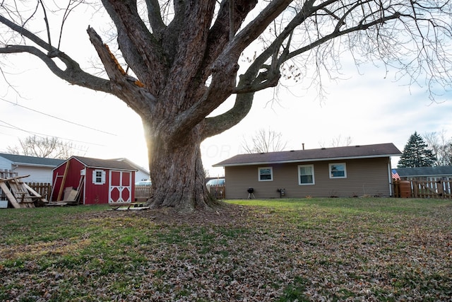 back of house featuring a lawn and a storage unit