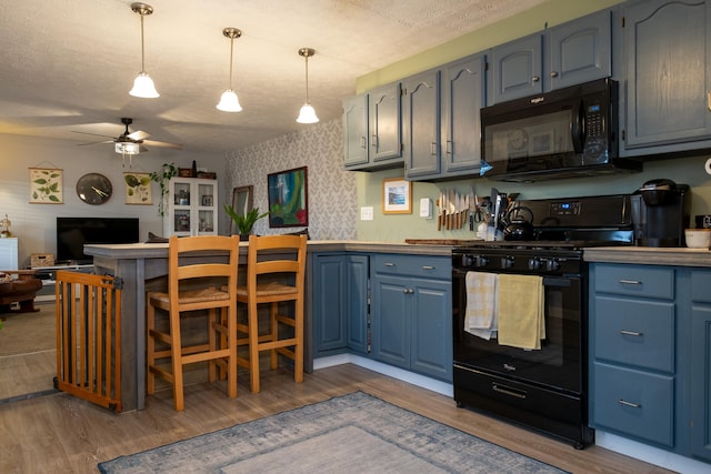 kitchen with ceiling fan, hanging light fixtures, dark wood-type flooring, a textured ceiling, and black appliances