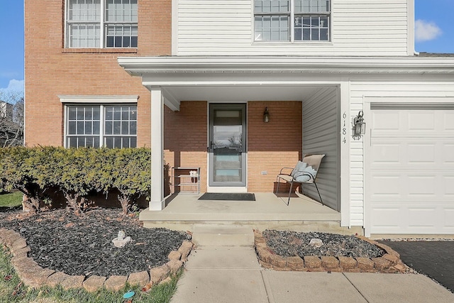 6184 Pirthshire St, Dublin, OH 43016 - doorway to property with a garage, covered porch, and brick siding