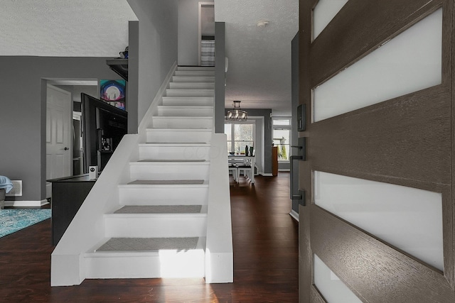 6184 Pirthshire St, Dublin, OH 43016 - stairs featuring baseboards, a textured ceiling, wood finished floors, and a notable chandelier