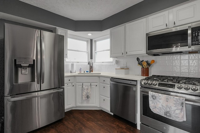 6184 Pirthshire St, Dublin, OH 43016 - kitchen with a sink, dark wood finished floors, stainless steel appliances, white cabinetry, and decorative backsplash