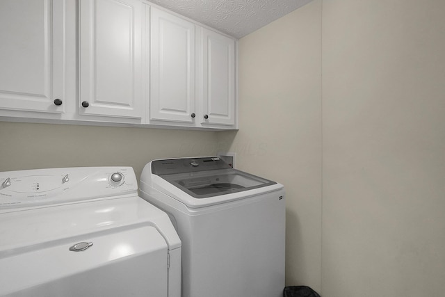 6184 Pirthshire St, Dublin, OH 43016 - laundry area featuring a textured ceiling, cabinet space, and washing machine and dryer