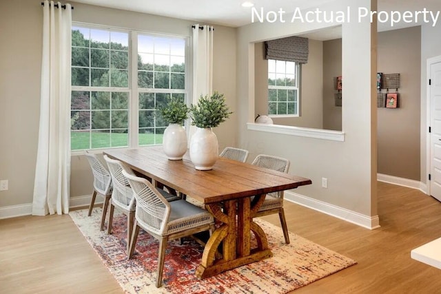 dining area with light wood-type flooring and baseboards