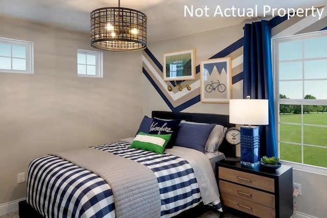 bedroom featuring a chandelier and baseboards