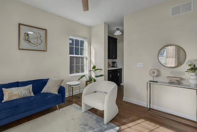 living area featuring ceiling fan and dark hardwood / wood-style flooring