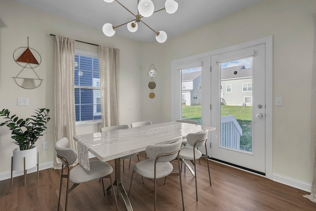 dining room featuring dark wood-type flooring and an inviting chandelier