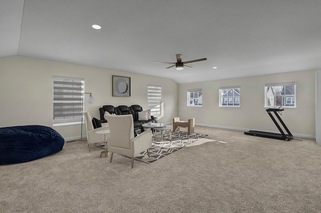 carpeted living room with ceiling fan and vaulted ceiling