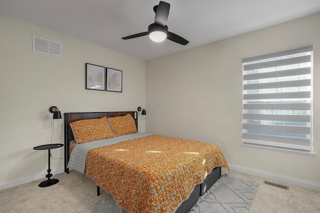 carpeted bedroom with multiple windows and ceiling fan