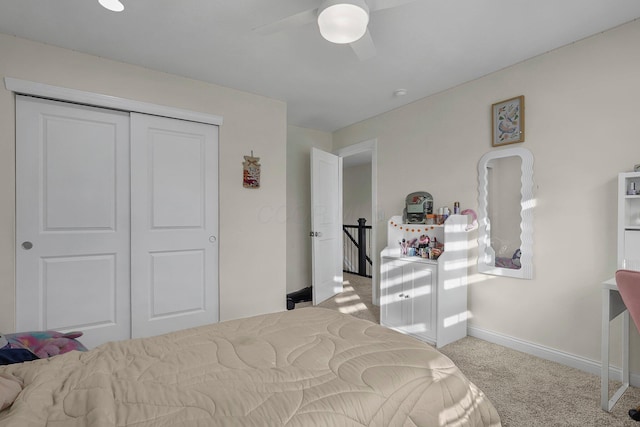 bedroom featuring ceiling fan, a closet, and light colored carpet