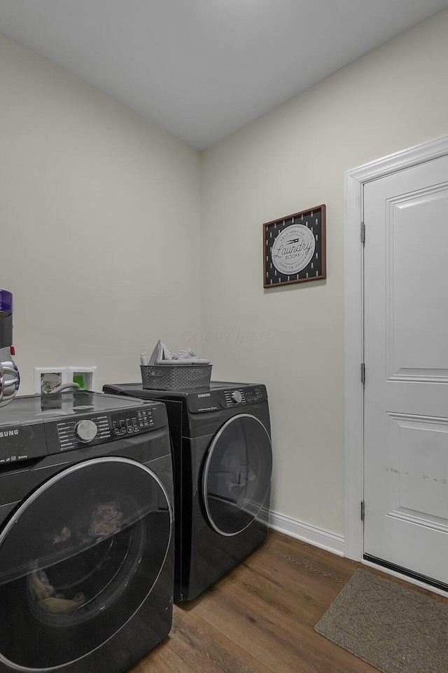 laundry area with dark hardwood / wood-style floors and washing machine and clothes dryer