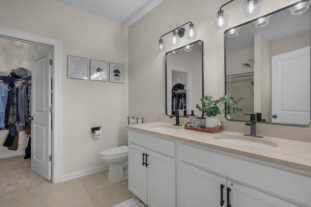 bathroom featuring a shower, tile patterned floors, vanity, and toilet