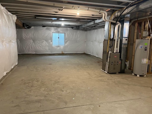 basement featuring heating unit and electric water heater