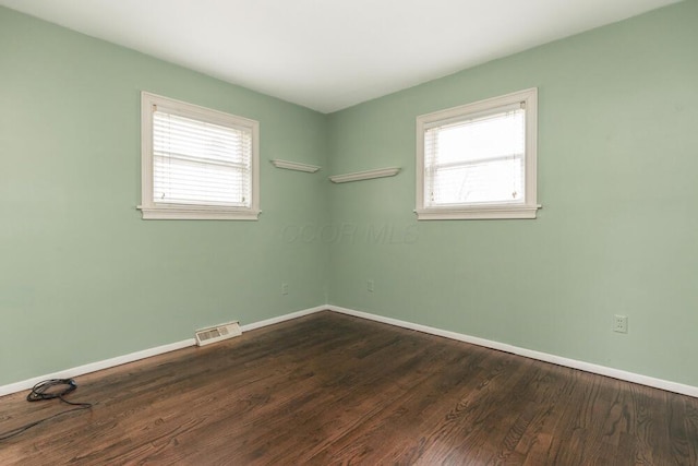 spare room with dark hardwood / wood-style floors