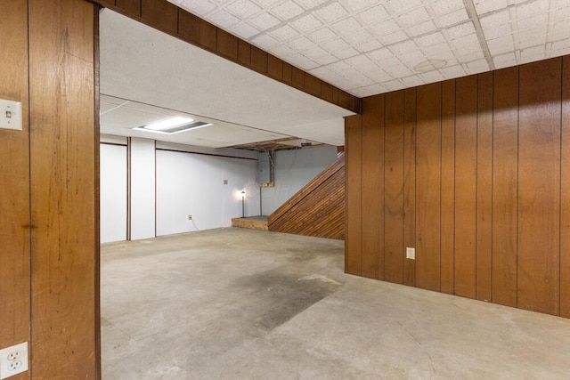 basement featuring wood walls