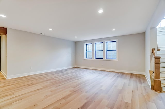 spare room with light wood finished floors, stairs, and recessed lighting