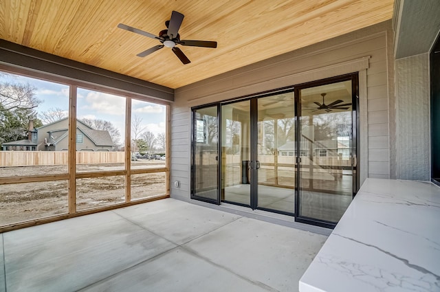 unfurnished sunroom featuring a ceiling fan and wood ceiling