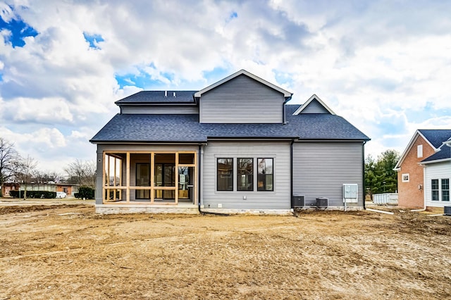 back of property featuring a sunroom, central AC unit, and roof with shingles