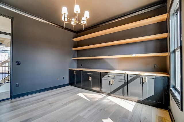 bar featuring light wood finished floors, visible vents, an inviting chandelier, ornamental molding, and baseboards