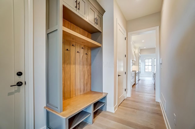 mudroom with light wood finished floors and baseboards