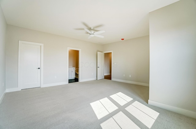 unfurnished bedroom with ensuite bath, baseboards, a ceiling fan, and light colored carpet