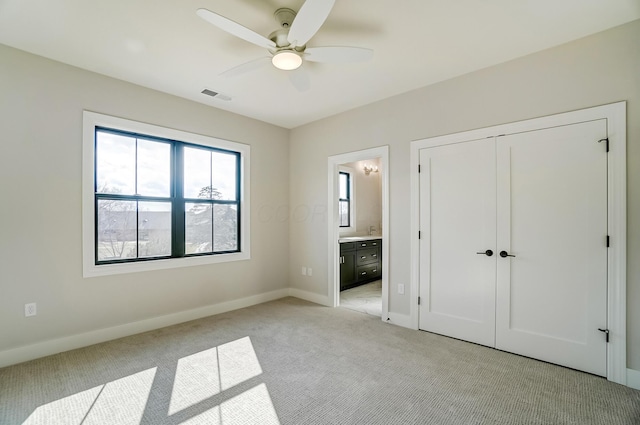 unfurnished bedroom featuring light carpet, baseboards, visible vents, and connected bathroom