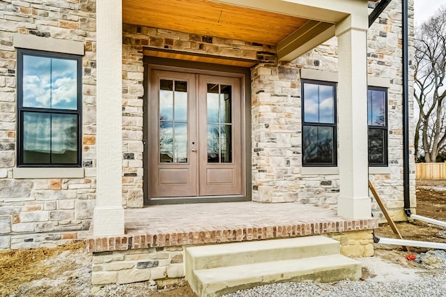 property entrance featuring stone siding, french doors, and crawl space