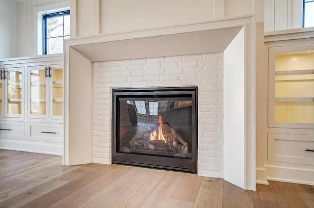 interior details with a brick fireplace and wood finished floors