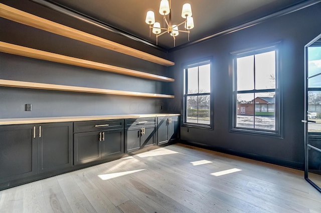 unfurnished dining area featuring light wood finished floors and a notable chandelier