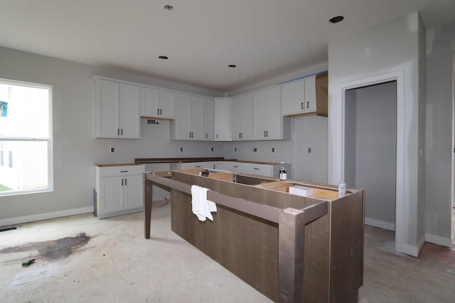 kitchen with a kitchen island, a wealth of natural light, and white cabinetry