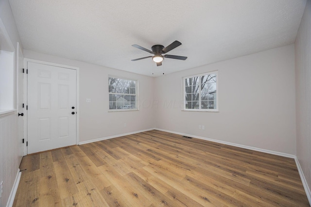 spare room with hardwood / wood-style floors, ceiling fan, and a textured ceiling