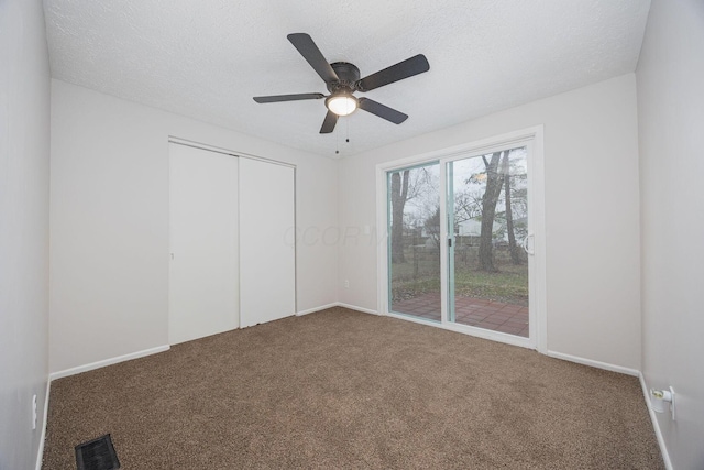 unfurnished bedroom featuring carpet flooring, ceiling fan, a textured ceiling, and a closet