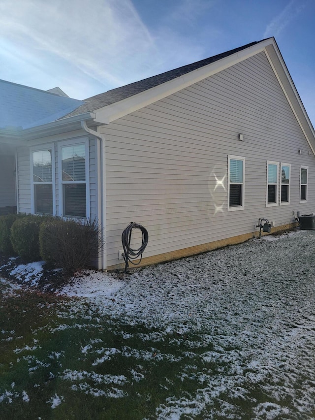 snow covered property with cooling unit