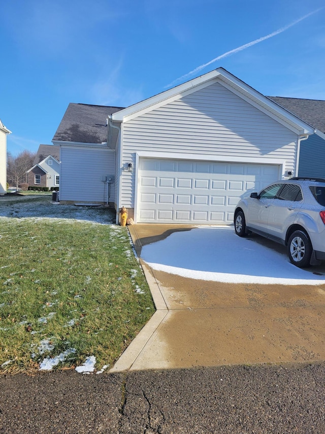 view of side of property featuring a garage and a lawn