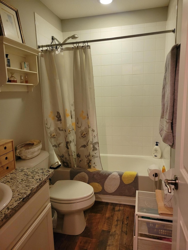 full bathroom with hardwood / wood-style floors, vanity, shower / tub combo, and toilet