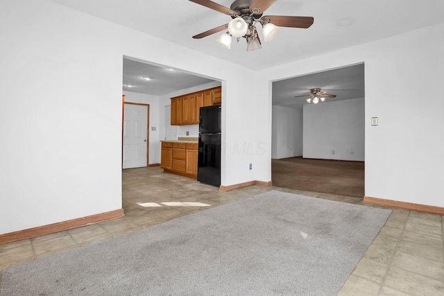 unfurnished living room with ceiling fan and light carpet