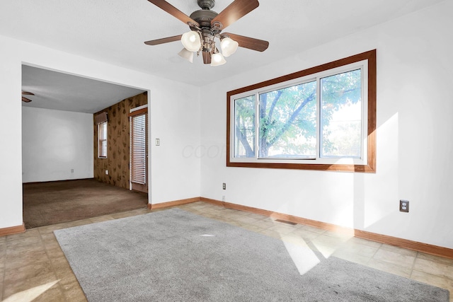 spare room featuring light colored carpet and ceiling fan