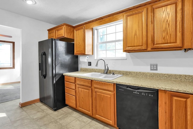 kitchen featuring sink, black appliances, and a textured ceiling