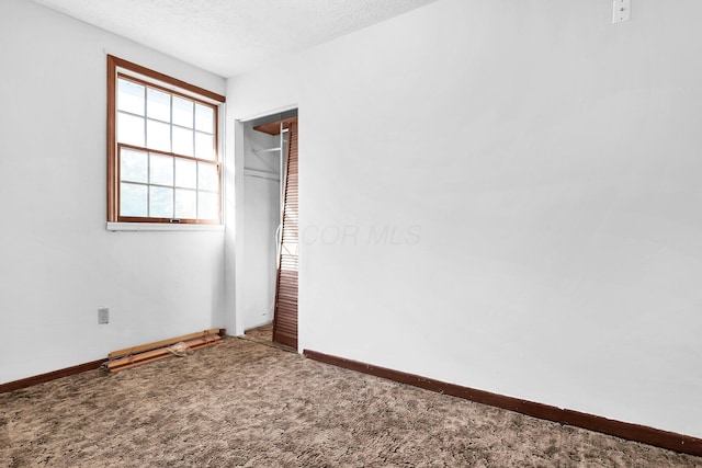 unfurnished bedroom with carpet, a textured ceiling, and a closet