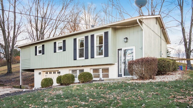 split foyer home featuring a garage and a front lawn