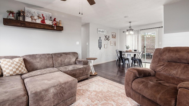 living room featuring ceiling fan with notable chandelier and wood-type flooring