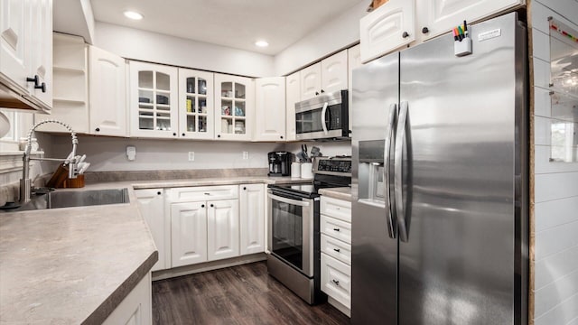 kitchen featuring sink, white cabinetry, stainless steel appliances, and dark wood-type flooring