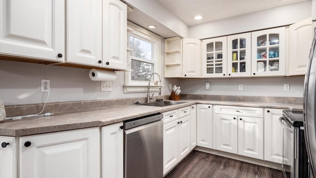 kitchen with dark wood-type flooring, sink, white cabinets, and stainless steel appliances