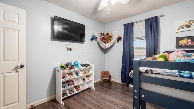 bedroom with a textured ceiling, ceiling fan, and dark wood-type flooring