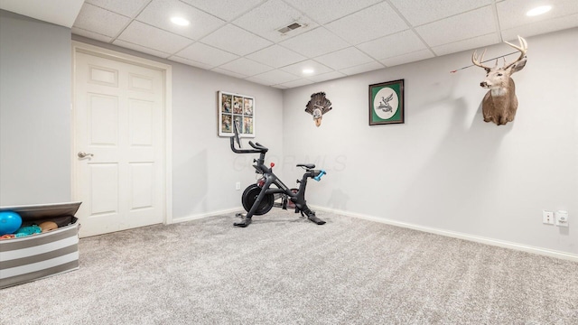 exercise room featuring carpet flooring and a paneled ceiling