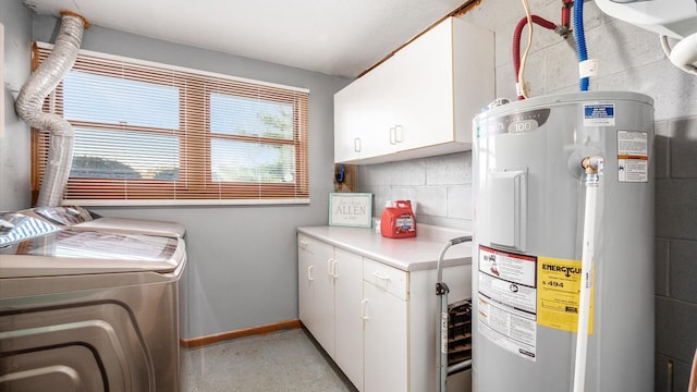 clothes washing area with cabinets, washing machine and dryer, and water heater