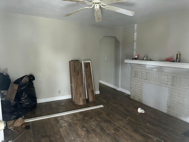 miscellaneous room with ceiling fan, dark hardwood / wood-style flooring, and a fireplace