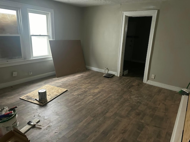 spare room with dark wood-type flooring and a textured ceiling